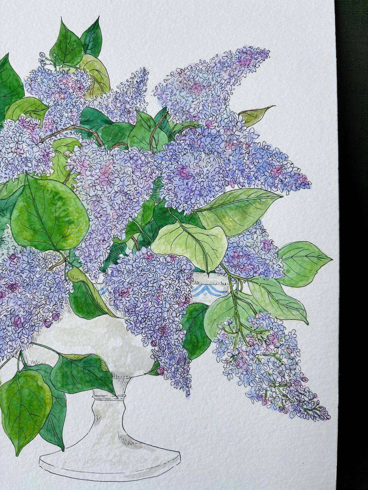 A watercolor and ink illustration of a large bouquet of purple lilacs with green leaves in a white pedestal vase, set against a textured white paper background.