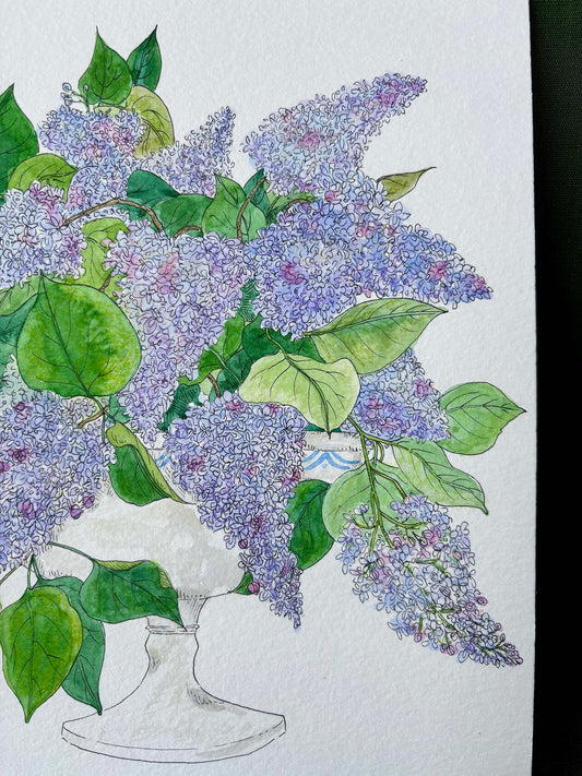 A watercolor and ink illustration of a large bouquet of purple lilacs with green leaves in a white pedestal vase, set against a textured white paper background.