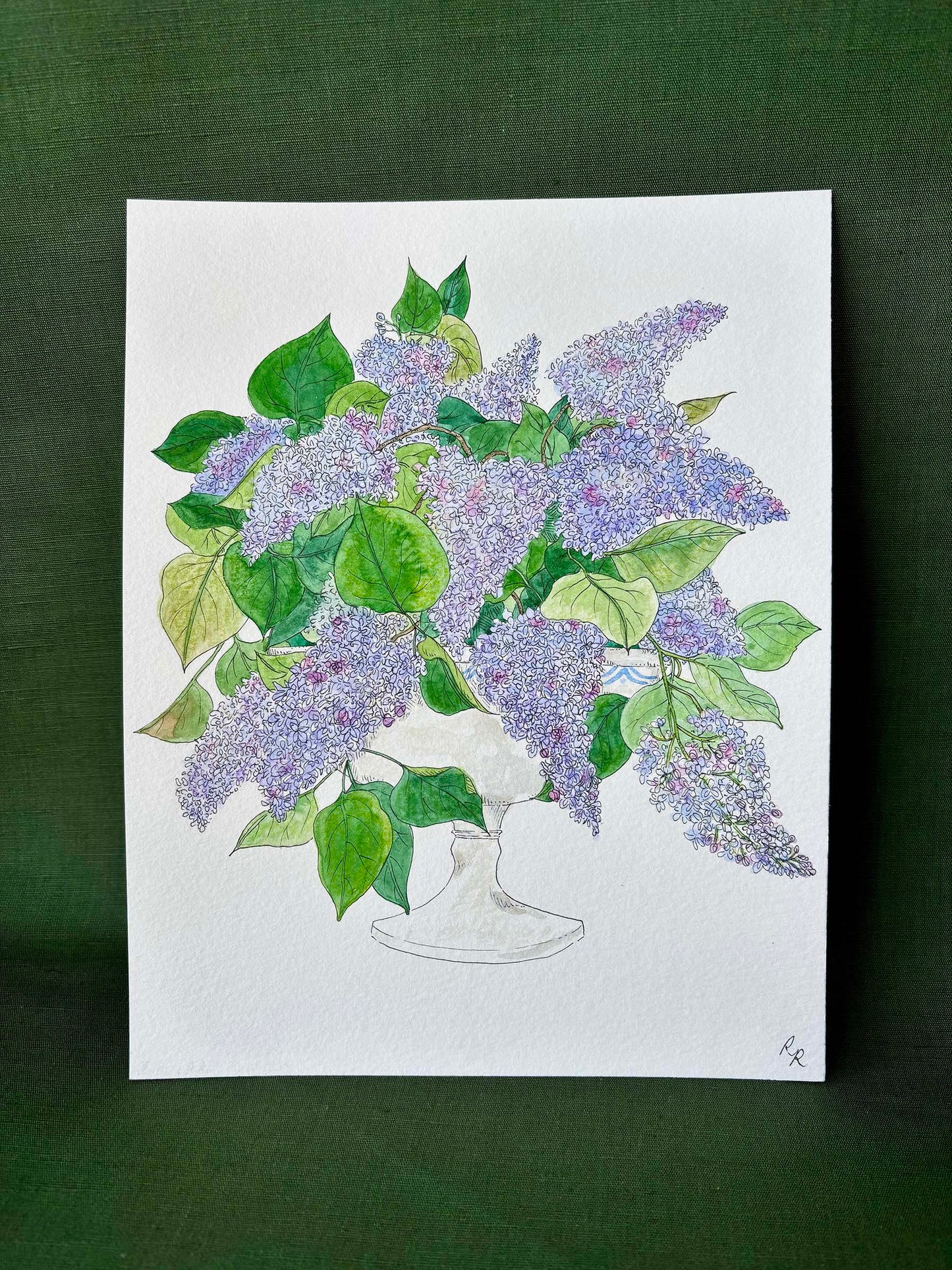 A botanical art print depicting a bouquet of purple lilacs and green leaves in a white vase.