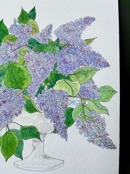 A watercolor and ink illustration of a large bouquet of purple lilacs with green leaves in a white pedestal vase, set against a textured white paper background.